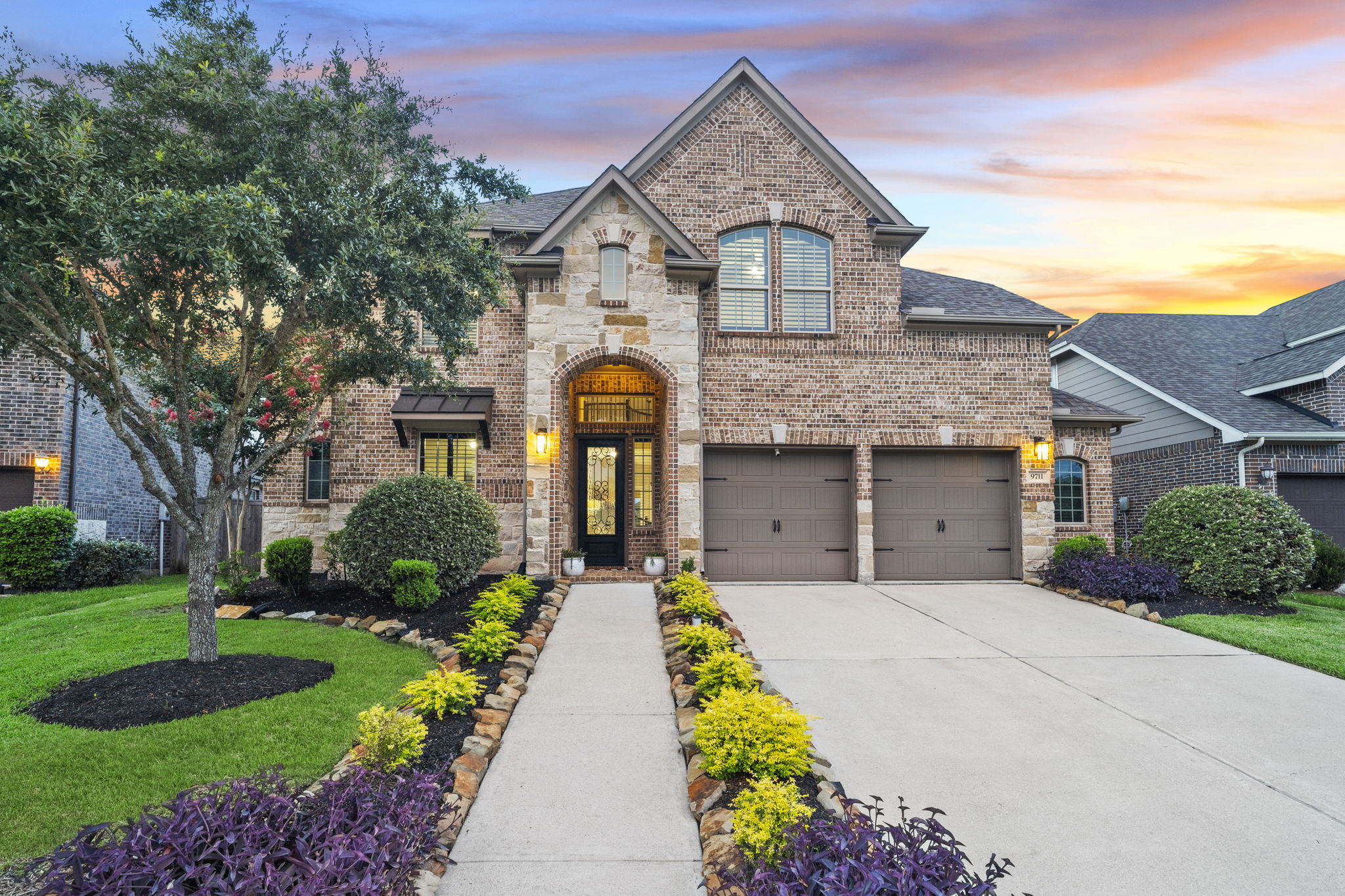 a two story single family home with a well maintained front yard